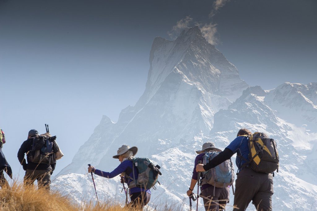 Snow-capped peaks of Nepal seen from low altitude trekking route, highlighting the best time to visit Nepal for mountain views, Mardi himal trek, Trekkers trekking with Mount Machhapuchhre in background